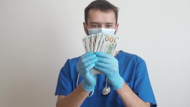 Lékař, který se drží v rukou, spočítá bankovky za sto dolarů. Platba zaměstnancům v červené zóně. Cena — Stock video