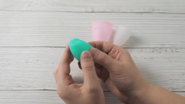 Mulher mão segurando copo menstrual e demonstrando métodos de dobramento Punch Down — Vídeo de Stock