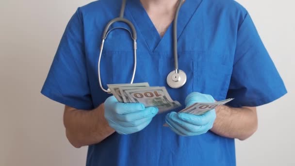 Lékař, který se drží v rukou, spočítá bankovky za sto dolarů. Platba zaměstnancům v červené zóně. Cena — Stock video