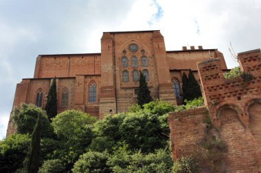 external walls of the monument church of san domenico among the narrow streets of the enchanting medieval siena in tuscany