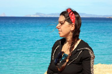 Yazın plaj tatilindeki beyaz kız Balear Adaları 'nın turkuaz ufkuna bakıyor.