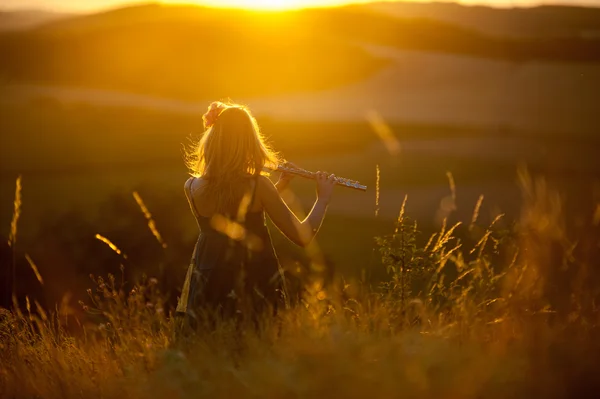 Hraní na flétnu v západu slunce Royalty Free Stock Obrázky