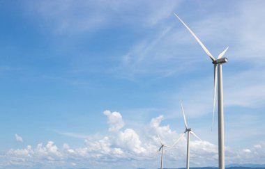 Rüzgar türbini mavi gökyüzü ile elektrik üretir.