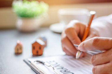 İş adamı başvuru formu dolduruyor. Ev sigortası kavramı.