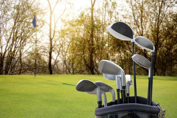 Golf equipment on green field background.
