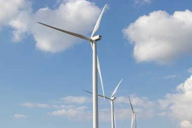 Rüzgar türbini mavi gökyüzü ile elektrik üretir.