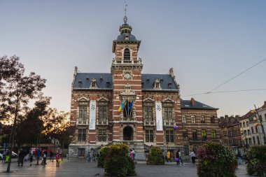 Brüksel, BELGIUM - 8 Ekim 2021: Twon Hall of Anderlecht, günbatımında. Aileler ve insanlar şehir meydanında günbatımının tadını çıkarıyorlar.