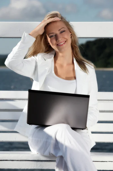 Vrouw met laptop op de pier — Stockfoto