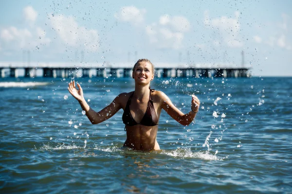 Jeune femme pulvérisation en mer — Photo