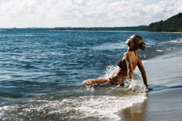 Jovem mulher salpicando no mar — Fotografia de Stock