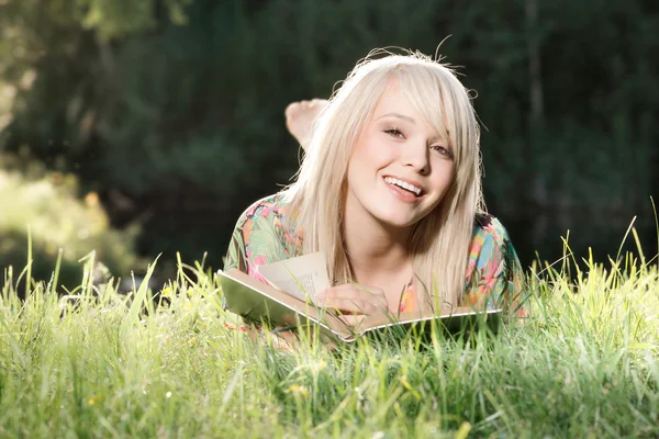 Een vrouw die een boek leest in het park — Stockfoto