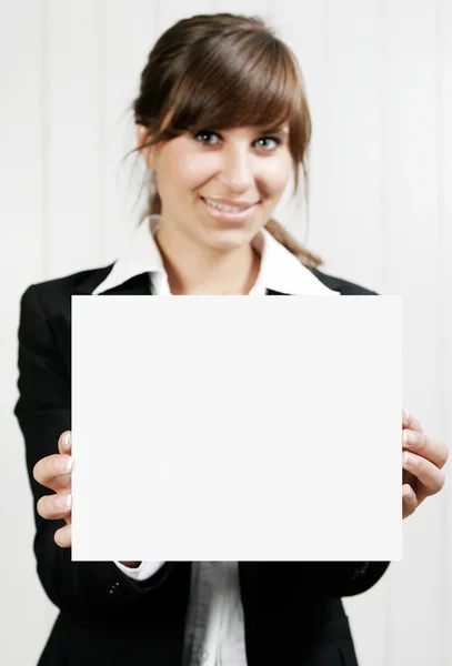 Mujer sonriente sosteniendo una tarjeta vacía — Foto de Stock