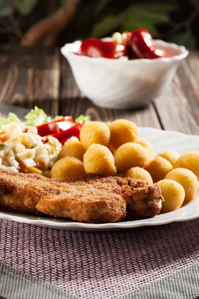 Breaded chop, prepared potatoes and salad — Stock Photo, Image