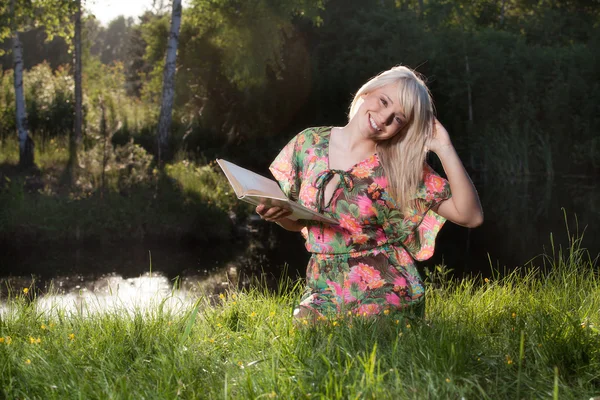 Jeune femme lisant un livre dans le parc — Photo