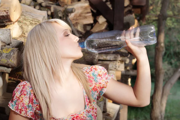 Красивая деревенская девушка пьет — стоковое фото
