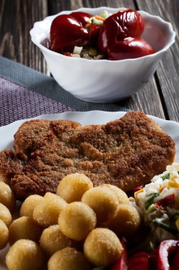 Breaded chop, prepared potatoes and salad clipart