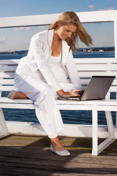 Mladá žena s laptopem na molu — Stock fotografie