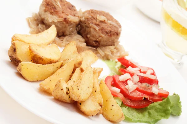 Meatballs with stewed onion and fried potato wedges — Stock Photo, Image