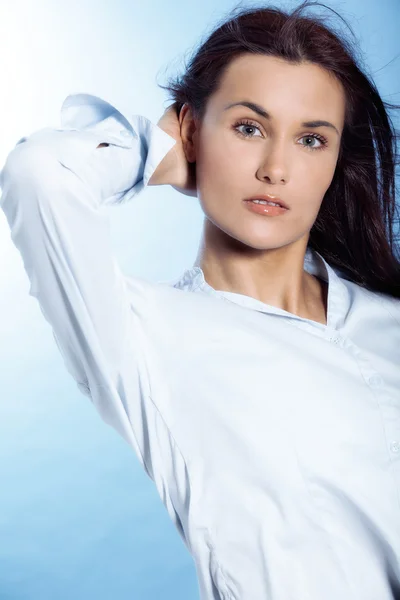 Retrato de mulher jovem bonita com cabelo voador no fundo azul — Fotografia de Stock