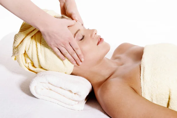 Young pretty woman laying down and receiving face massage — Stock Photo, Image