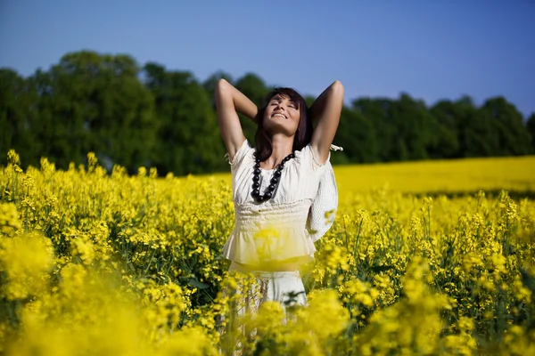 Woman in the yellow rape field — Stock Photo, Image