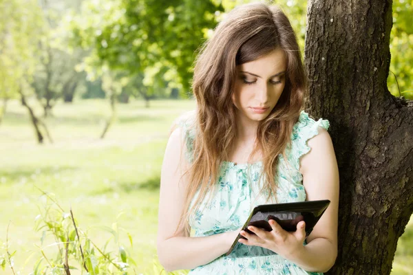 Jovem mulher olhando para seu tablet — Fotografia de Stock