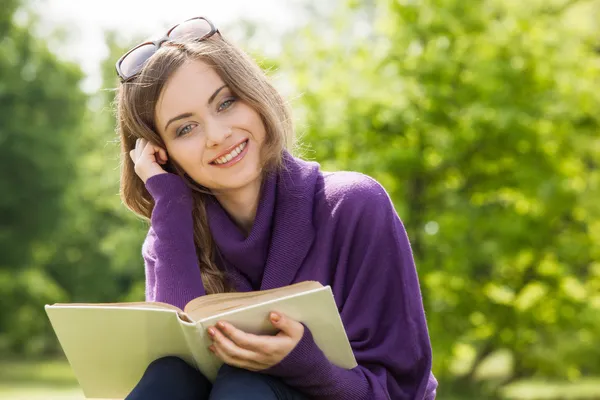 Fille lisant un livre dans le parc — Photo