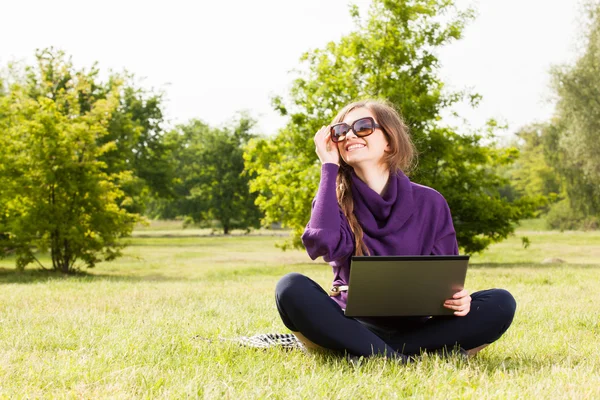 Jonge vrouw die werkt op haar laptop — Stockfoto