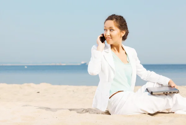 Mulher falando no celular em uma praia — Fotografia de Stock