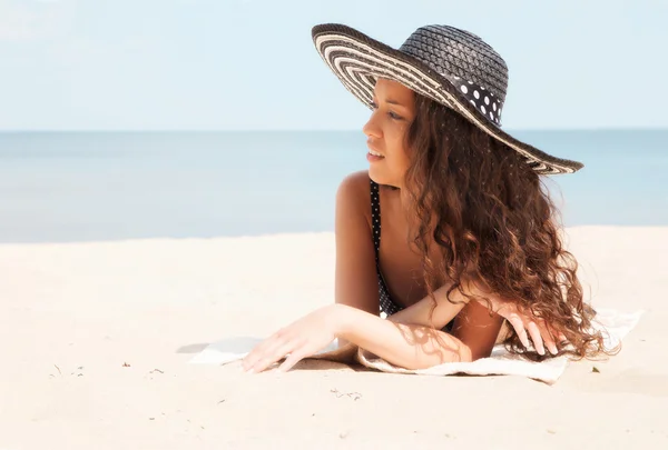 Jong meisje liggend op het strand — Stockfoto