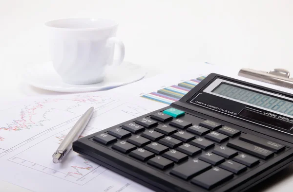 Calculator met pen op grafiek — Stockfoto