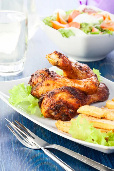 Chicken drumsticks with french fries — Stock Photo, Image