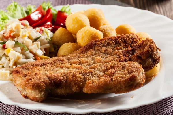 Breaded cutlet and prepared potatoes — Stock Photo, Image