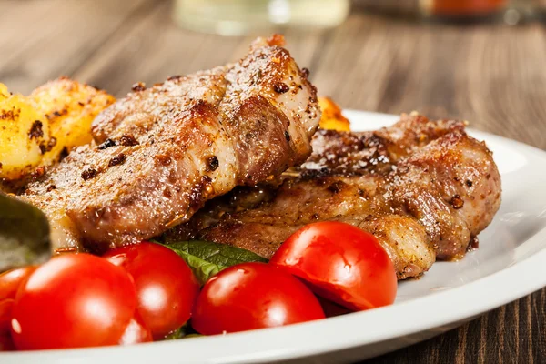 Gegrilde steaks, gebakken aardappelen en groenten — Stockfoto