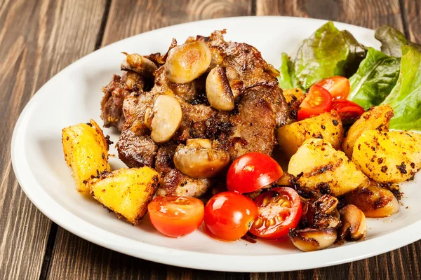 Gebratenes Schweinekotelett mit Champignons und Pommes — Stockfoto