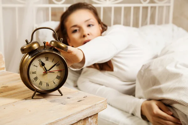 Woman in bed turning off alarm clock — Stock Photo, Image
