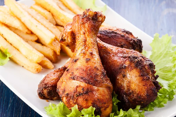 Chicken drumsticks with chips — Stock Photo, Image
