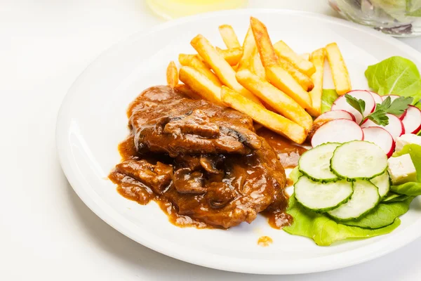 Pork chop met saus, paddestoelen en chips — Stockfoto