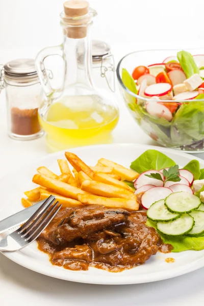 Pork chop with sauce, mushrooms and chips — Stock Photo, Image