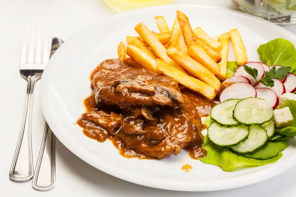 Chuleta de cerdo con salsa, champiñones y patatas fritas — Foto de Stock