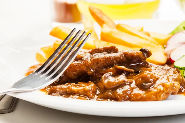 Chuleta de cerdo con salsa, champiñones y patatas fritas — Foto de Stock