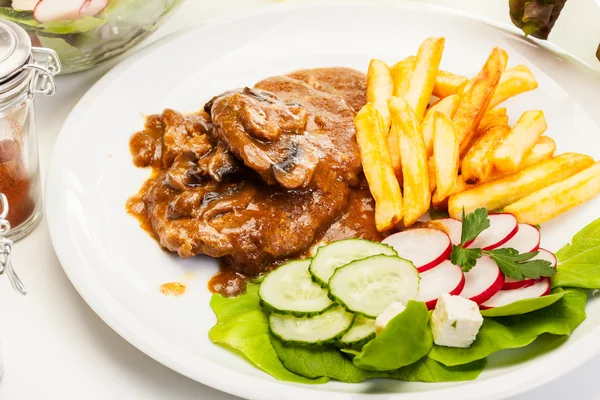 Chuleta de cerdo con salsa, champiñones y patatas fritas — Foto de Stock