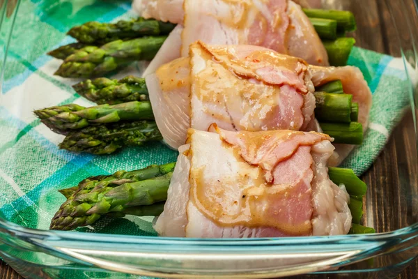 Asperges verpakt in kip en bacon in een ovenschaal — Stockfoto