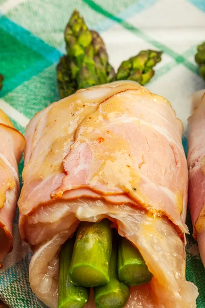 Asparagus wrapped in chicken and bacon in a baking dish — Stock Photo, Image