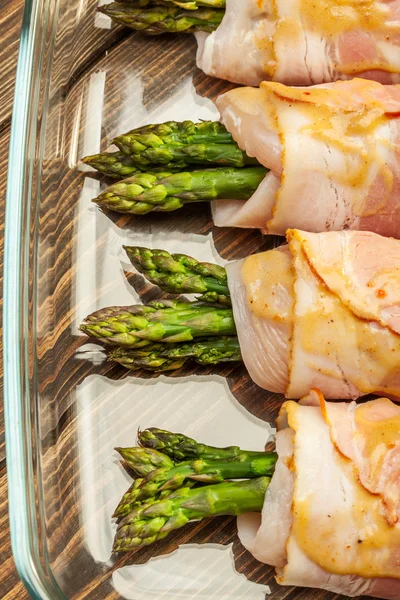 Tavuk ve domuz pastırması bir pişirme çanağı içinde sarılı kuşkonmaz — Stok fotoğraf