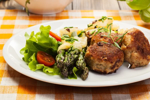 Köttbullar serveras med kokt potatis och sparris — Stockfoto