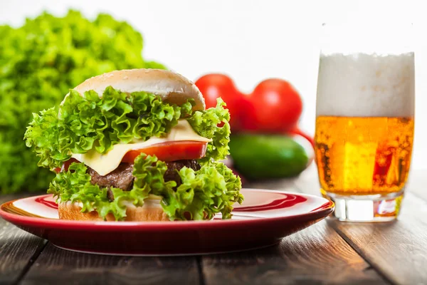 Hamburguesa con queso en un plato con cerveza — Foto de Stock