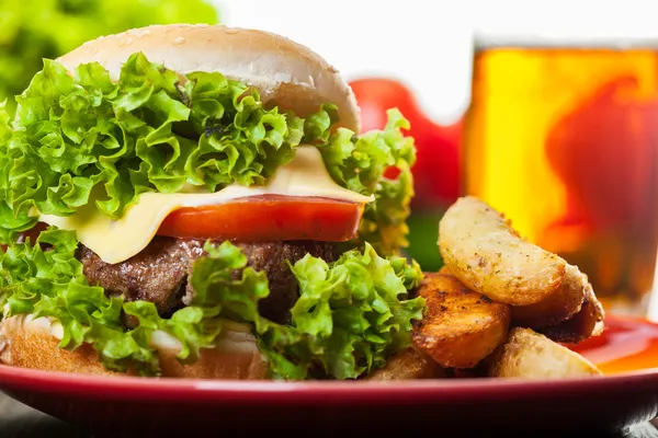 Cheeseburger aux pommes de terre frites dans une assiette avec bière — Photo