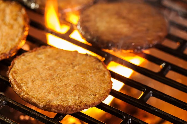 Hamburger karbanátky na grilu s ohněm pod — Stock fotografie