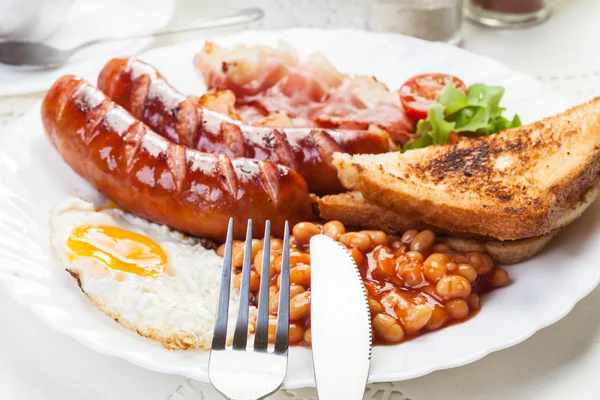 Desayuno inglés completo con tocino, salchichas, huevo frito y horneado — Foto de Stock